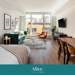 a studio apartment with furniture and large windows