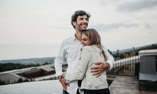 a man and woman hugging on rooftop terrace